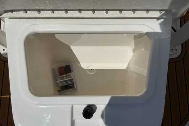 Slide: The Image of Open storage compartment on 2027 Bayliner Trophy T20CC boat with small item inside. - 13