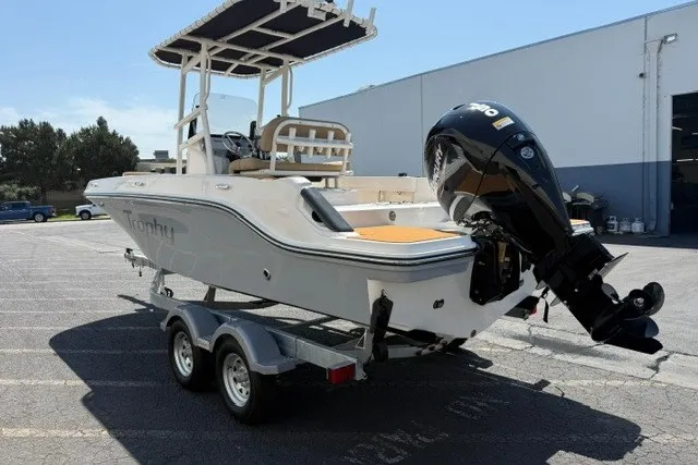 Slide: The Image of 2027 Bayliner Trophy T20CC boat on trailer, parked outdoors, featuring a powerful outboard motor. - 21