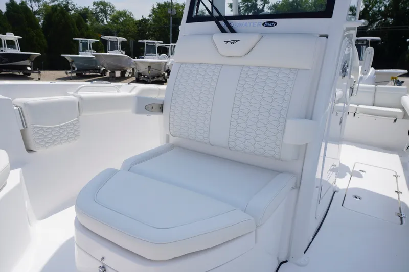Slide: The Image of 2027 Tidewater 256 LXF boat interior with white cushioned seating. - 15