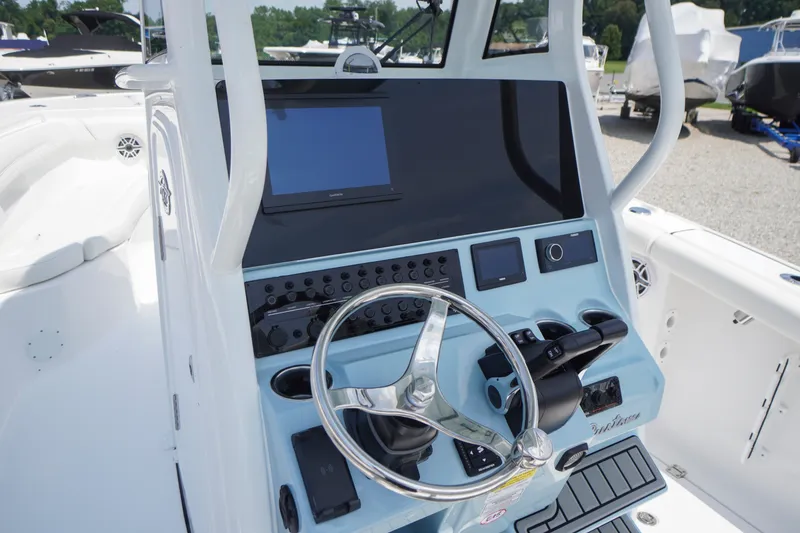 Slide: The Image of 2027 Tidewater 256 LXF boat dashboard with steering wheel and electronic controls. - 29