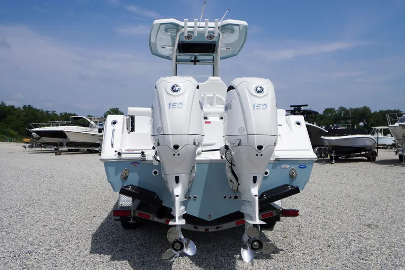 Slide: The Image of 2027 Tidewater 256 LXF boat with dual outboard engines on a gravel lot. - 74
