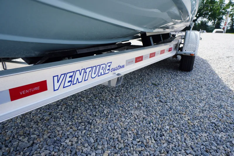 Slide: The Image of Trailer for 2027 Tidewater 256 LXF boat on gravel surface. - 80