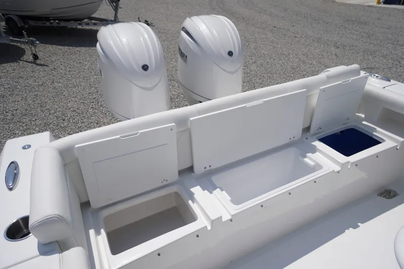 Slide: The Image of 2027 Tidewater 256 LXF boat with open storage compartments and dual outboard motors. - 58