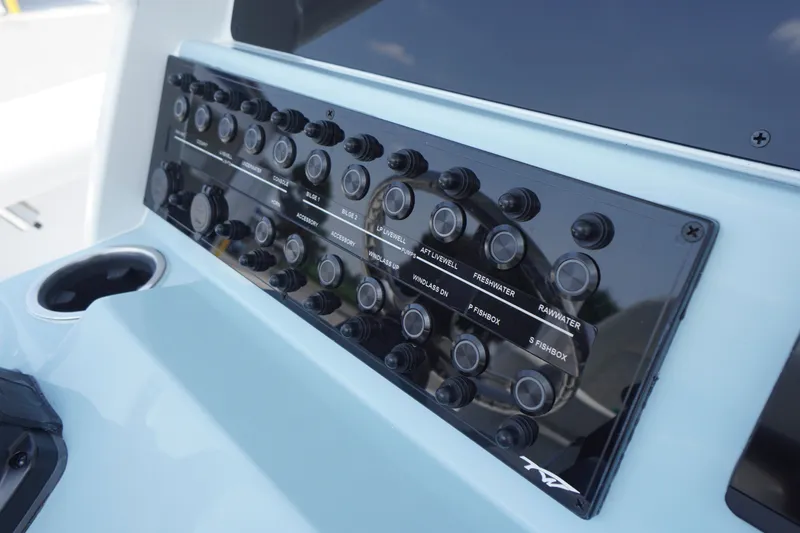 Slide: The Image of Control panel of 2027 Tidewater 256 LXF boat with labeled switches and buttons. - 32