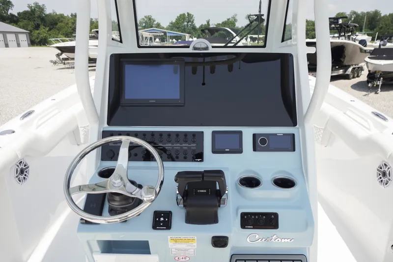 Slide: The Image of 2027 Tidewater 256 LXF boat dashboard with steering wheel and electronic controls. - 30