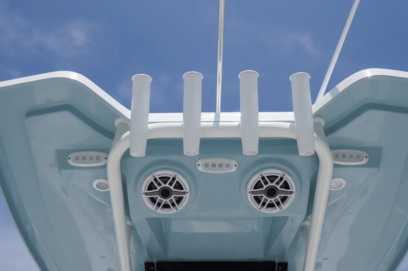 Slide: The Image of 2027 Tidewater 256 LXF boat roof with rod holders and speakers against blue sky. - 71