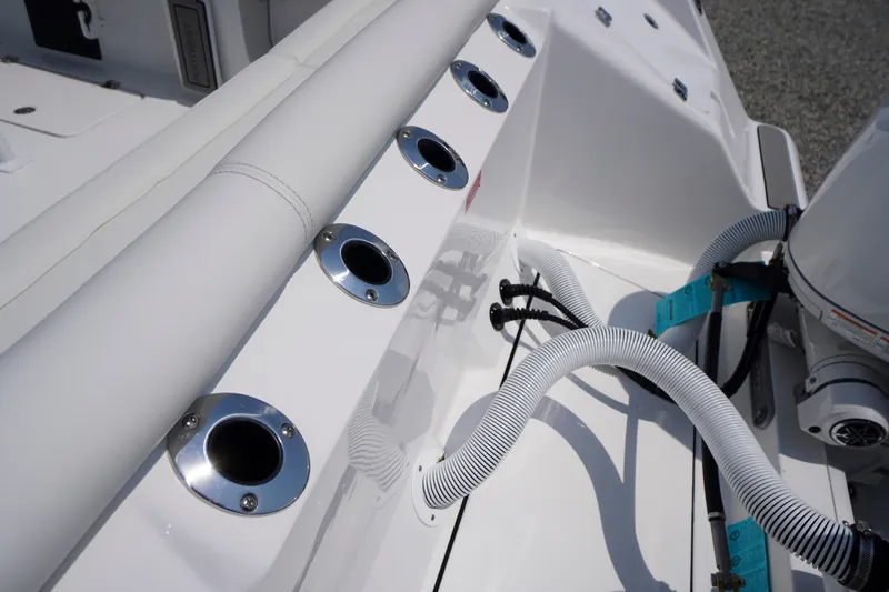 Slide: The Image of 2027 Tidewater 256 LXF boat deck with rod holders and engine hoses. - 69