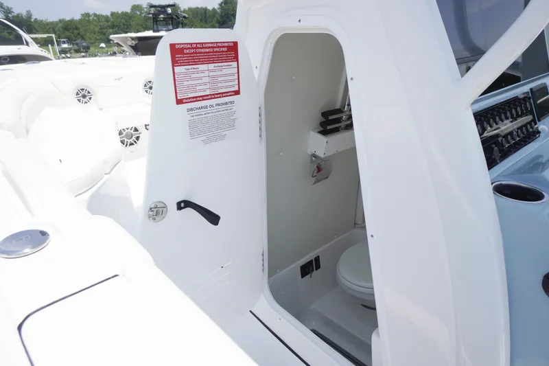 Slide: The Image of 2027 Tidewater 256 LXF boat interior with open door revealing compact restroom. - 25