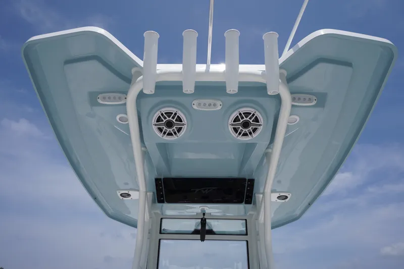 Slide: The Image of Tidewater 256 LXF 2027 boat roof with speakers and rod holders against blue sky. - 70