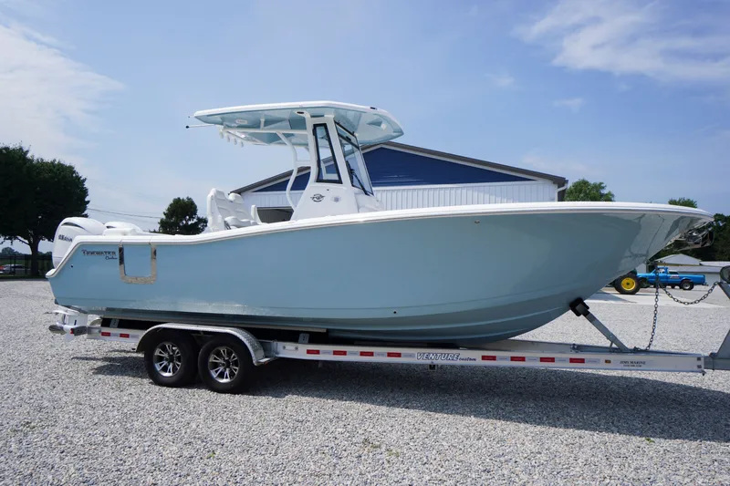 Slide: The Image of 2027 Tidewater 256 LXF boat on trailer, light blue hull, parked outdoors. - 82