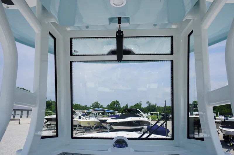 Slide: The Image of Interior view of 2027 Tidewater 256 LXF boat, showcasing windshield and marina background. - 41