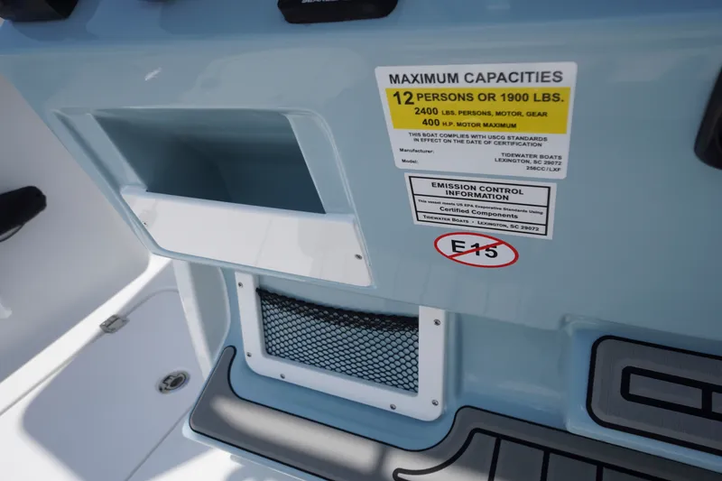 Slide: The Image of Tidewater 256 LXF 2027 boat capacity and emission control labels on blue interior. - 36