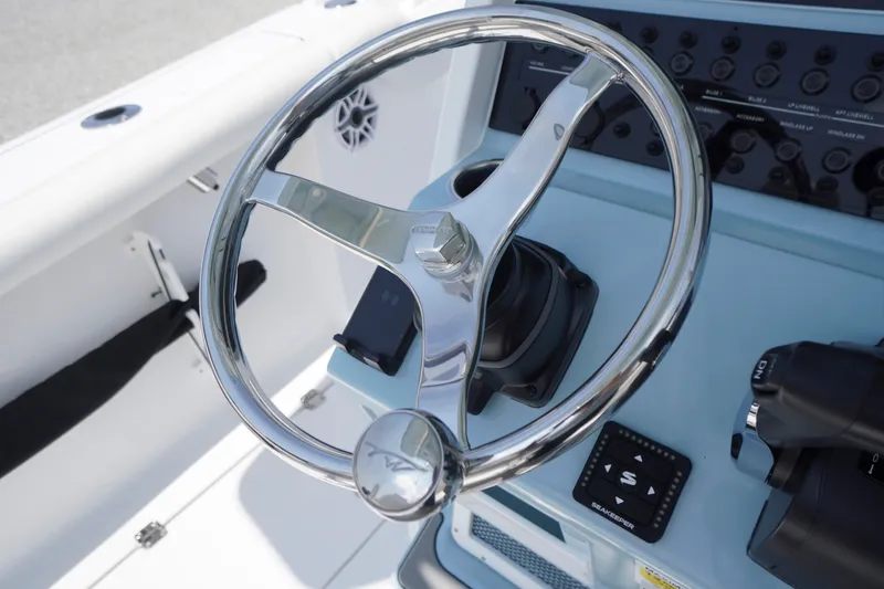 Slide: The Image of Steering wheel of 2027 Tidewater 256 LXF boat, featuring modern controls and dashboard. - 39