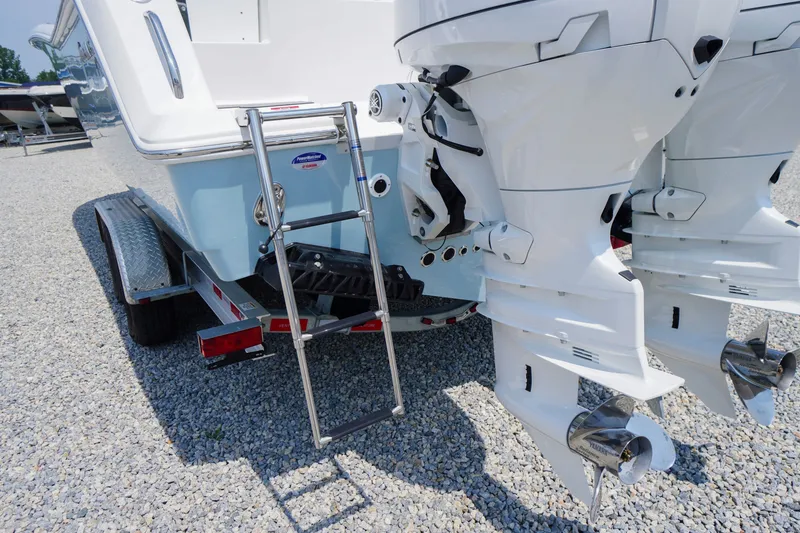 Slide: The Image of 2027 Tidewater 256 LXF boat with dual outboard motors and trailer ladder. - 73