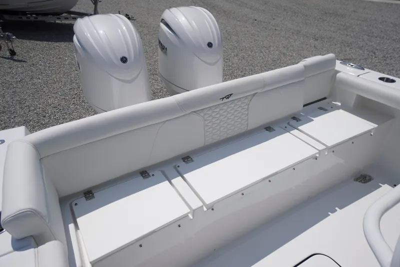 Slide: The Image of 2027 Tidewater 256 LXF boat with dual engines and white seating in a gravel lot. - 57