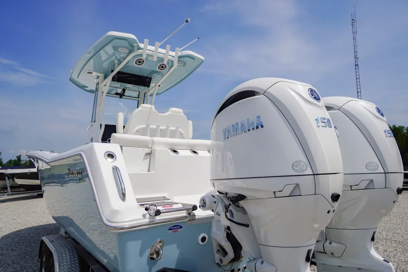 Slide: The Image of 2027 Tidewater 256 LXF boat with dual Yamaha 150 engines, parked on a trailer. - 72