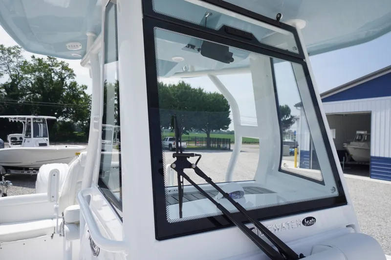 Slide: The Image of 2027 Tidewater 256 LXF boat with sleek windshield design in a marina setting. - 21