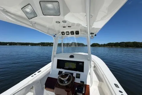Slide: The Image of 2007 Regulator 29 Forward Seating boat on calm water, featuring a sleek helm and spacious seating. - 44