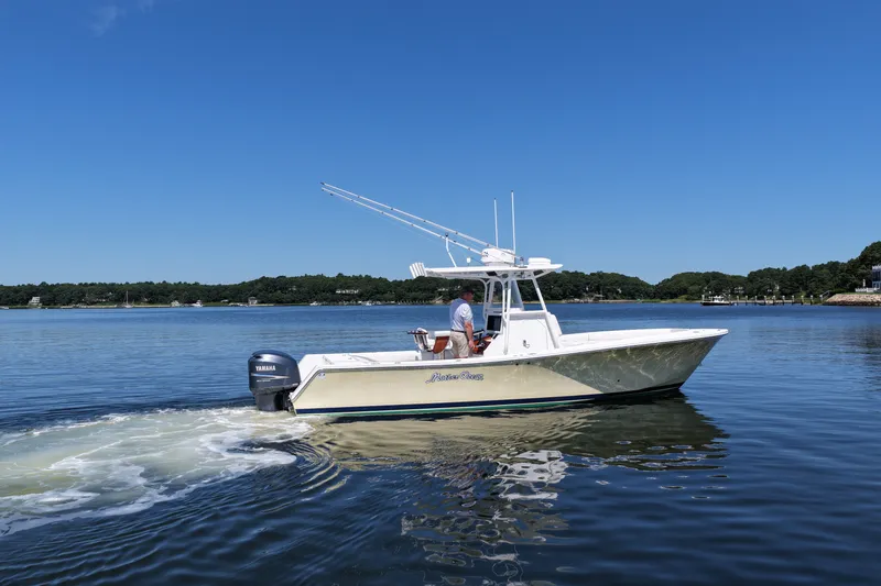 Slide: The Image of 2007 Regulator 29 Forward Seating boat cruising on a calm lake under clear blue skies. - 15
