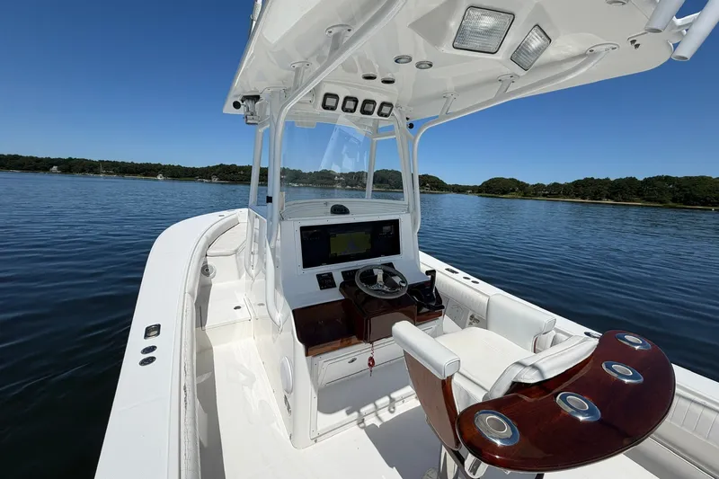 Slide: The Image of 2007 Regulator 29 Forward Seating boat on calm water, featuring a sleek helm and seating area. - 45