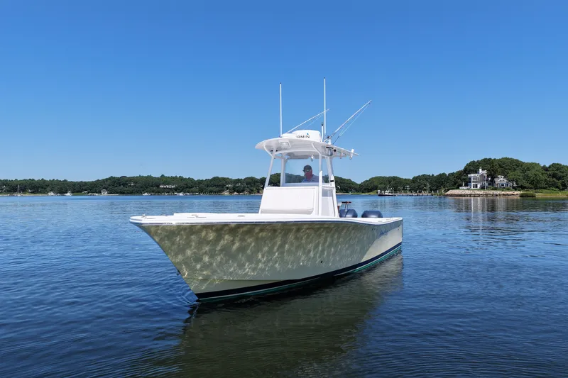 Slide: The Image of 2007 Regulator 29 Forward Seating boat on calm water under clear blue sky. - 3