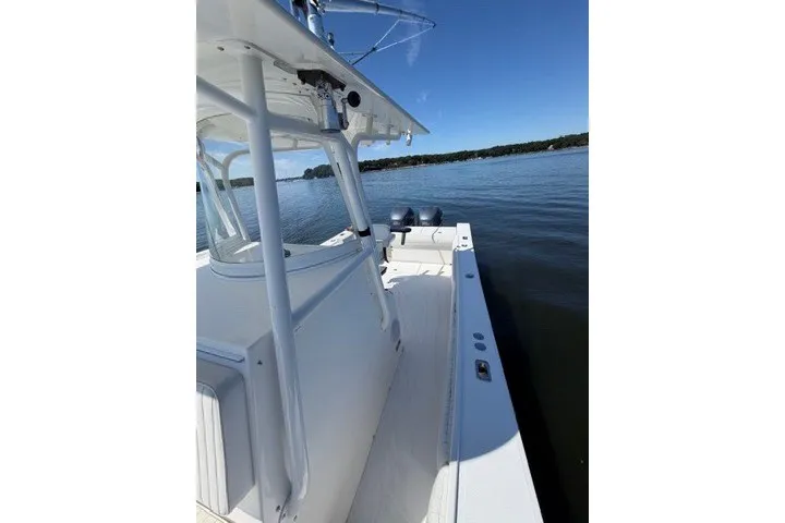 Slide: The Image of 2007 Regulator 29 Forward Seating boat on calm water under clear blue sky. - 41
