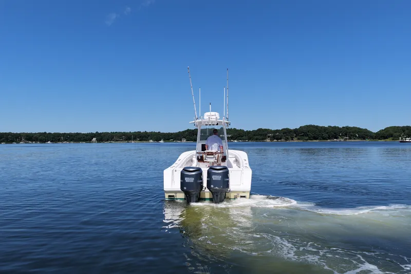 Slide: The Image of 2007 Regulator 29 Forward Seating boat cruising on a calm lake under a clear blue sky. - 12