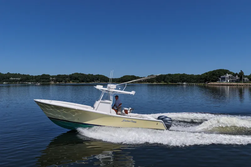 Slide: The Image of 2007 Regulator 29 Forward Seating boat cruising on a calm lake under clear blue skies. - 1