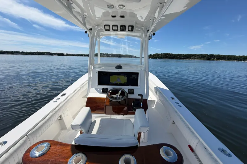 Slide: The Image of 2007 Regulator 29 Forward Seating boat on calm water, featuring a sleek helm and navigation system. - 50