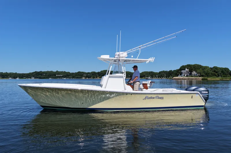 Slide: The Image of 2007 Regulator 29 Forward Seating boat on calm water, with a person at the helm. - 5