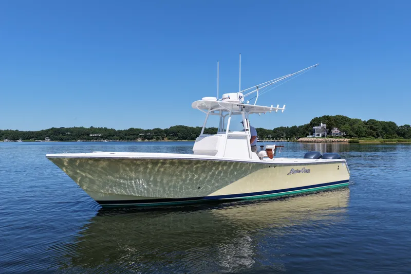 Slide: The Image of 2007 Regulator 29 Forward Seating boat on calm water, clear blue sky background. - 4