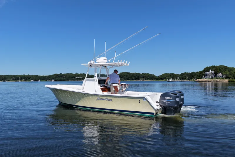 Slide: The Image of 2007 Regulator 29 Forward Seating boat cruising on a calm lake under a clear blue sky. - 8