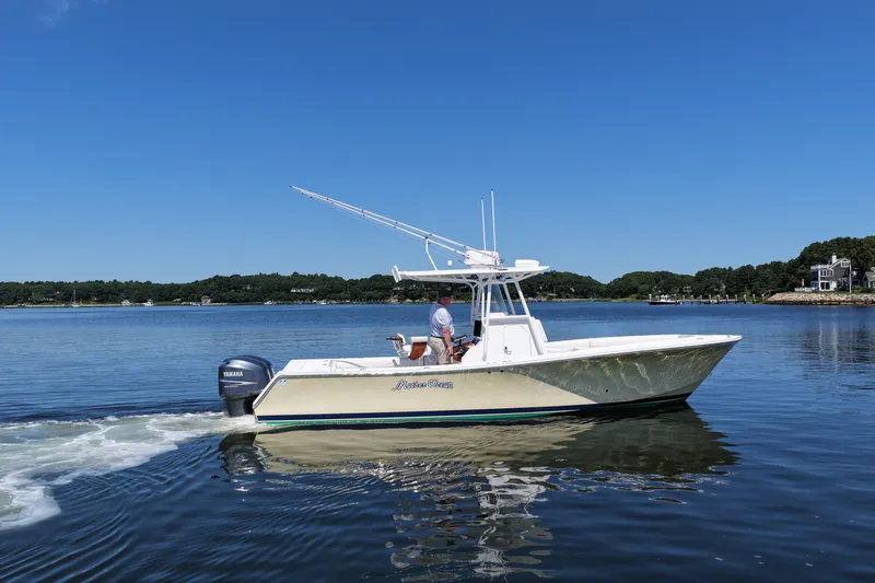 Slide: The Image of 2007 Regulator 29 Forward Seating boat cruising on a calm lake under a clear blue sky. - 16