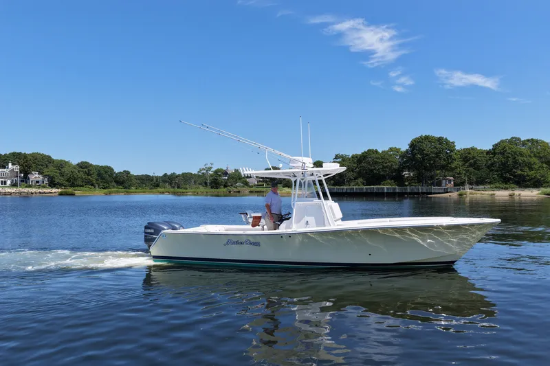 Slide: The Image of 2007 Regulator 29 Forward Seating boat cruising on a calm lake under a clear blue sky. - 20