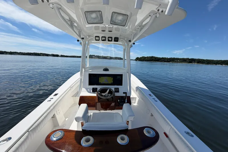 Slide: The Image of 2007 Regulator 29 Forward Seating boat on calm water, featuring a sleek helm and spacious deck. - 51