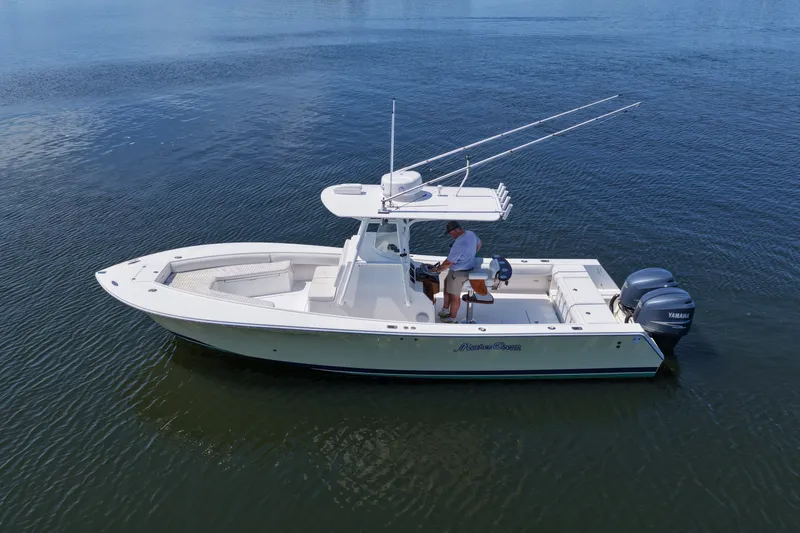 Slide: The Image of 2007 Regulator 29 Forward Seating boat on calm water, featuring dual Yamaha engines. - 25