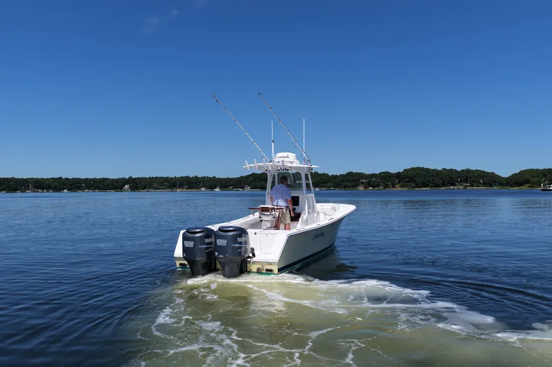 Slide: The Image of 2007 Regulator 29 Forward Seating boat cruising on a calm lake under a clear blue sky. - 13