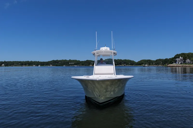 Slide: The Image of 2007 Regulator 29 Forward Seating boat on calm water under clear blue sky. - 2