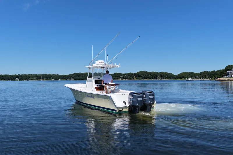 Slide: The Image of 2007 Regulator 29 Forward Seating boat on calm water, clear sky background. - 9