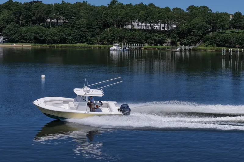 Slide: The Image of 2007 Regulator 29 Forward Seating boat cruising on a calm lake with scenic background. - 32
