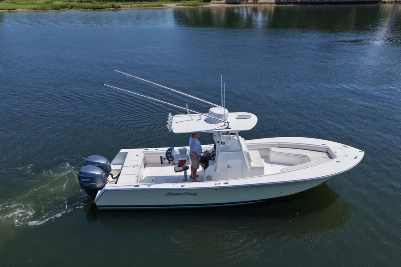 Slide: The Image of 2007 Regulator 29 Forward Seating boat on calm water, featuring dual Yamaha engines. - 24