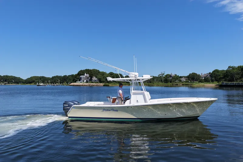 Slide: The Image of 2007 Regulator 29 Forward Seating boat cruising on a calm lake under a clear blue sky. - 19