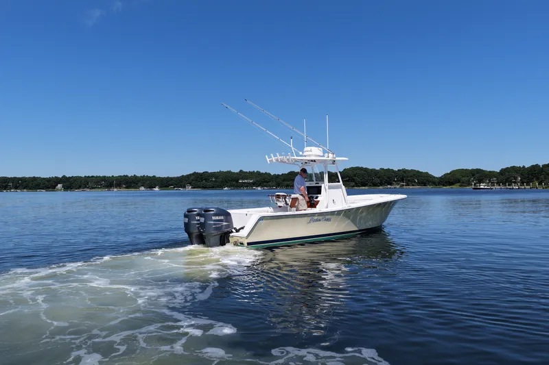 Slide: The Image of 2007 Regulator 29 Forward Seating boat cruising on a calm lake under a clear blue sky. - 14