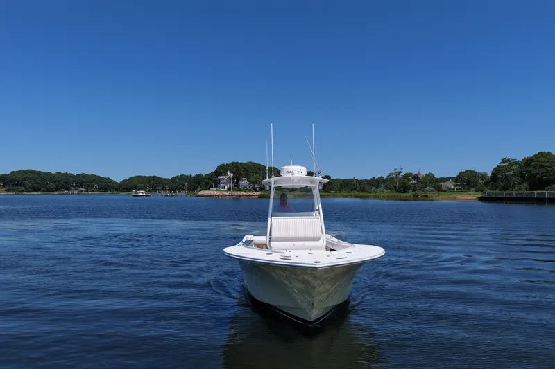 Slide: The Image of 2007 Regulator 29 Forward Seating boat on calm water under clear blue sky. - 22