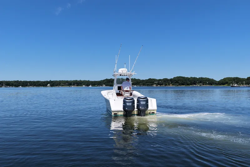Slide: The Image of 2007 Regulator 29 Forward Seating boat cruising on a calm lake under a clear blue sky. - 10