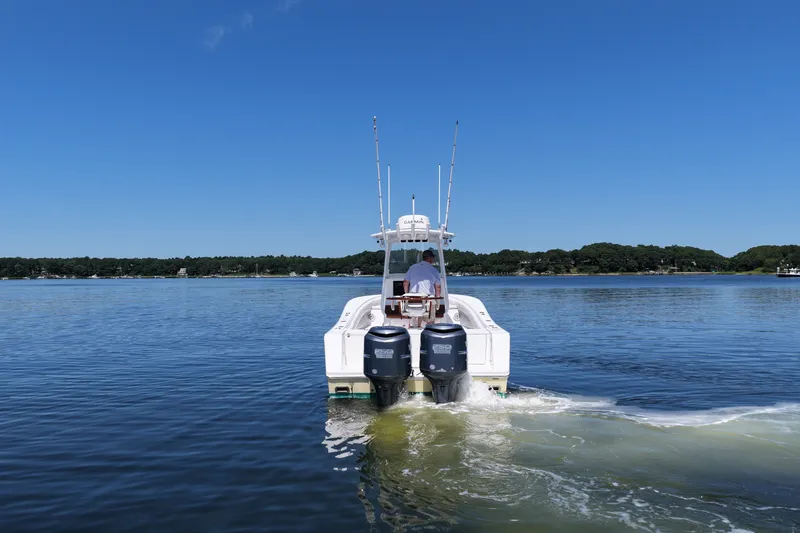 Slide: The Image of 2007 Regulator 29 Forward Seating boat cruising on a calm lake under a clear blue sky. - 11