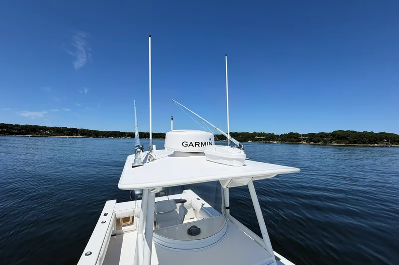 Slide: The Image of 2007 Regulator 29 Forward Seating boat on calm water under clear blue sky. - 38