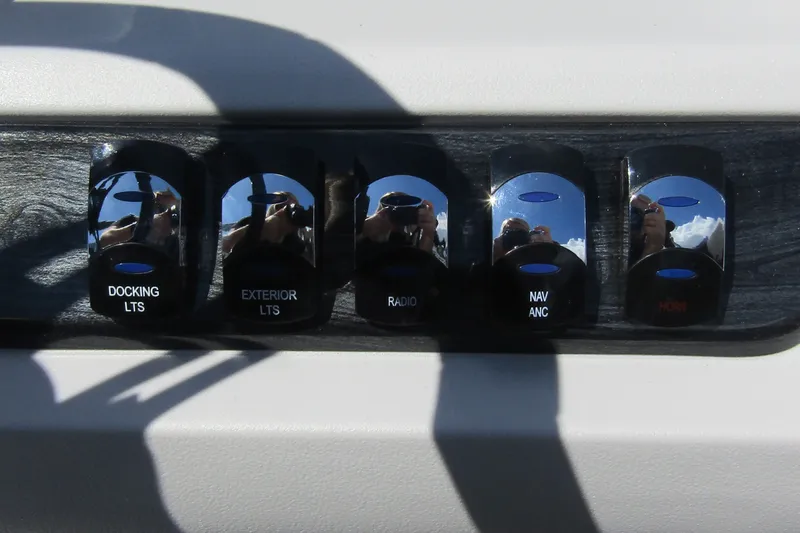 Slide: The Image of Control panel of 2026 Tahoe Pontoon LTZ Cruise Rear Bench 23 with various switches. - 22