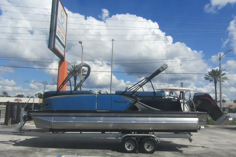 The Image of 2026 Tahoe Pontoon LTZ Cruise Rear Bench 23 on trailer under blue sky. - 0