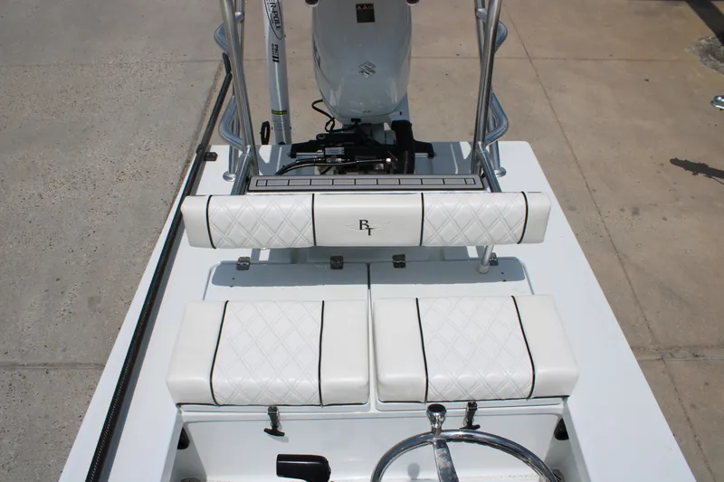 Slide: The Image of 2022 Beavertail Skiffs Mosquito 18' boat interior with white cushioned seating and steering wheel. - 16